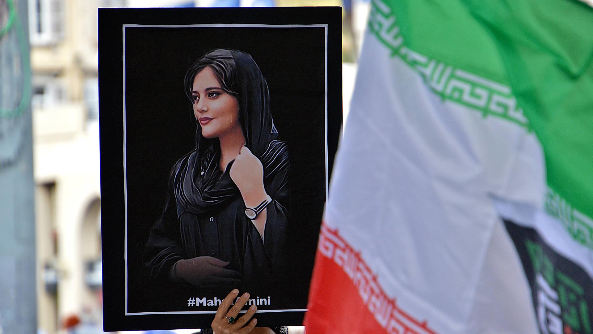 Eine Demonstrantin hält ein Plakat mit dem Bild von Mahsa Amini. Die Menschen versammelten sich in Marseille, um die Frauen und das iranische Volk zu unterstützen. 