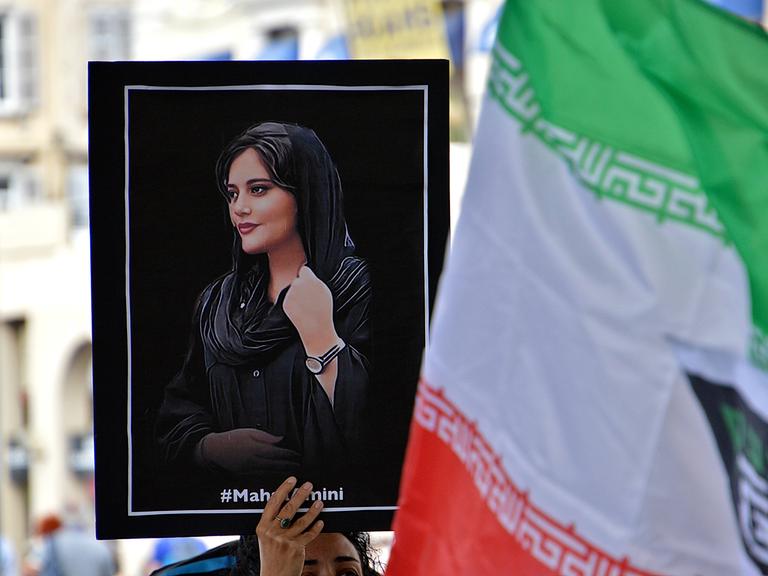 Eine Demonstrantin hält ein Plakat mit dem Bild von Mahsa Amini. Die Menschen versammelten sich in Marseille, um die Frauen und das iranische Volk zu unterstützen. 
