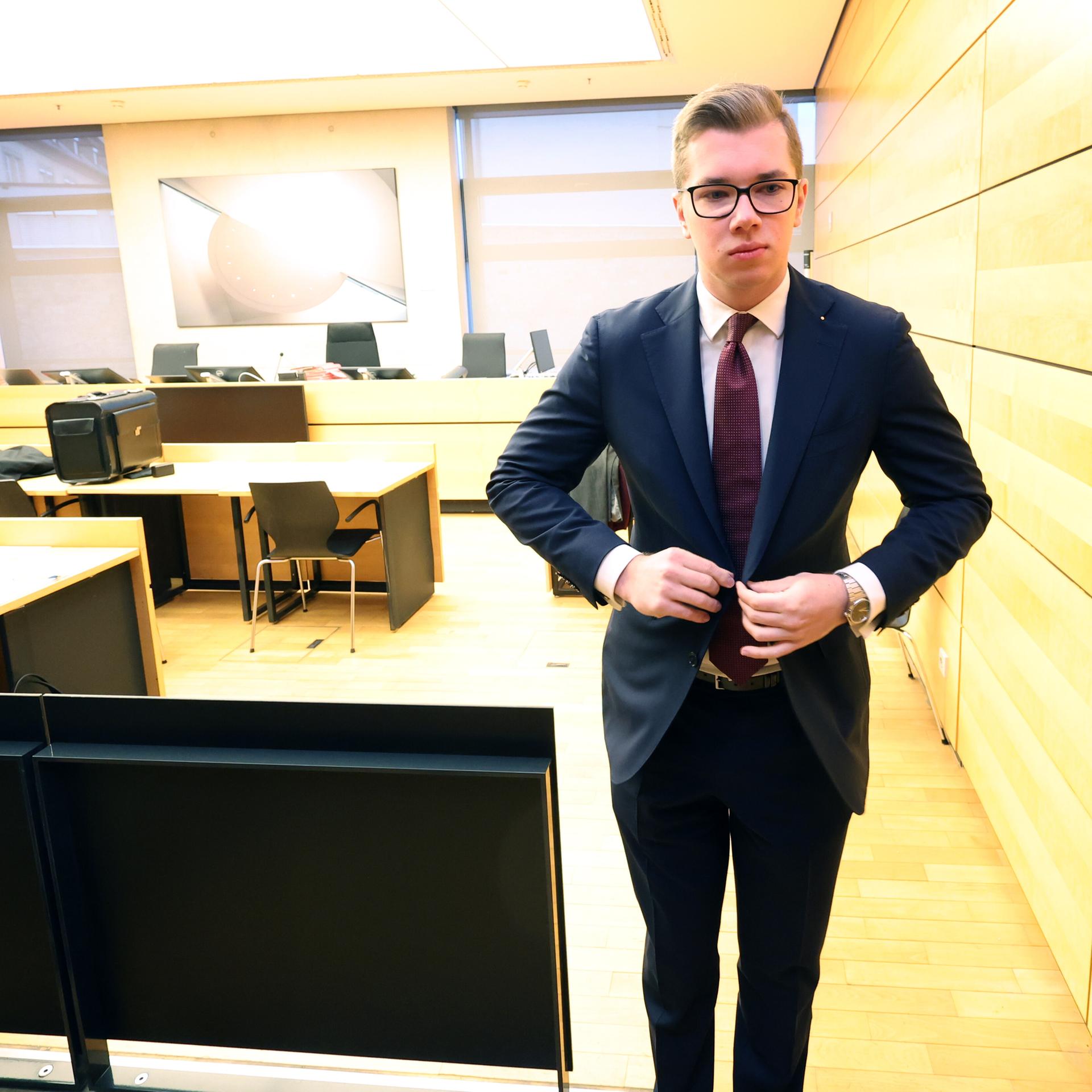 Der bayerische AfD-Landtagsabgeordnete Daniel Halemba verlässt vor Prozessbeginn den Gerichtssaal, um vor Journalisten ein Statement abzugeben. Links sitzt seine Verteidigerin Isabella Sanna.