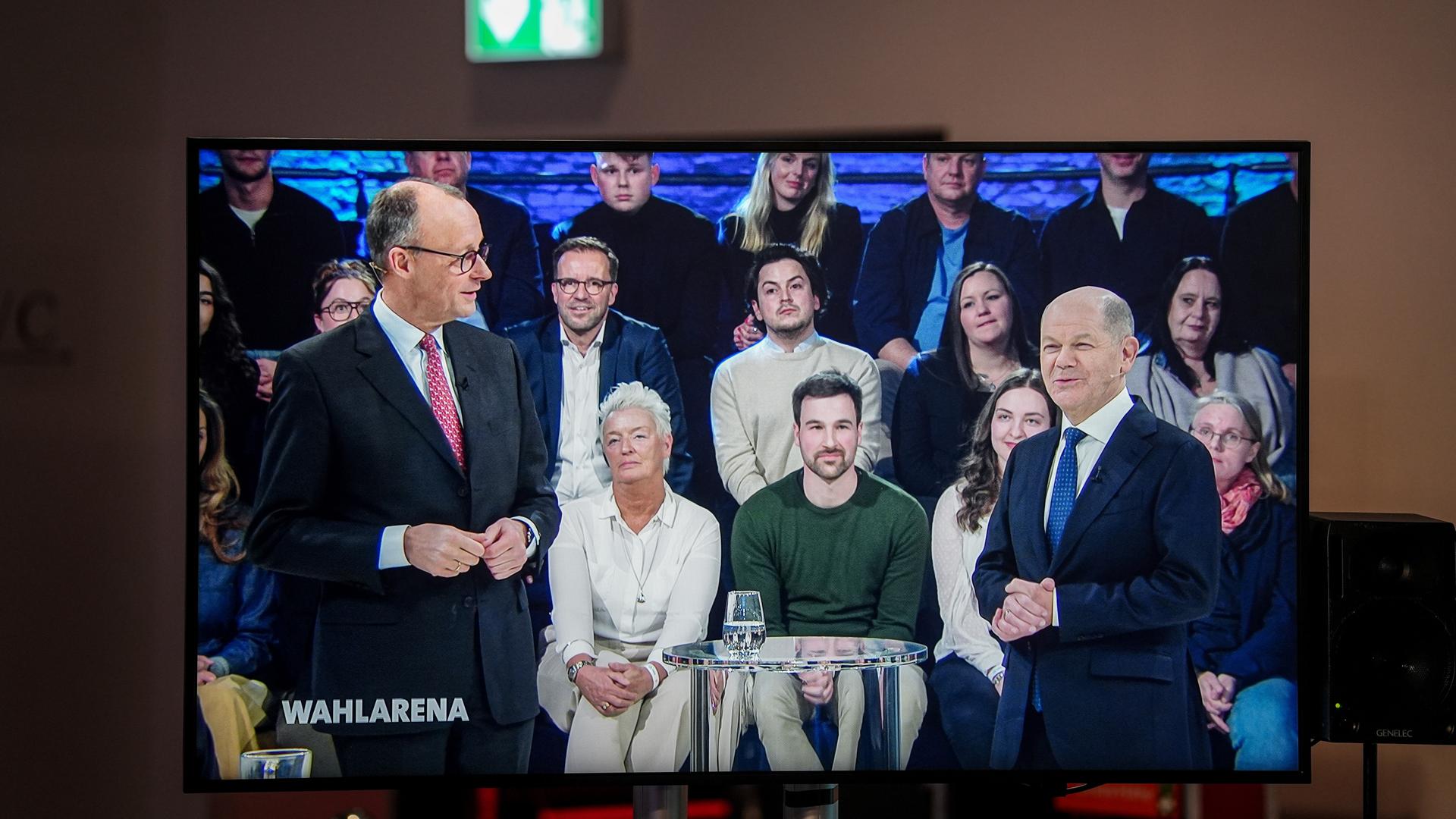 Friedrich Merz (links), Unions-Kanzlerkandidat und CDU-Bundesvorsitzender, und Bundeskanzler Olaf Scholz (SPD) sind gemeinsam auf einem Bildschirm während der Sendung ARD "Wahlarena" zu sehen.