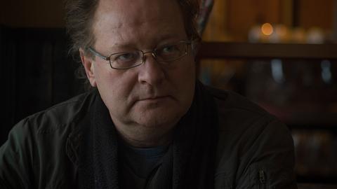 Der Schriftsteller Christoph Brumme blickt auf dem Bild blickt er nachdenklich.