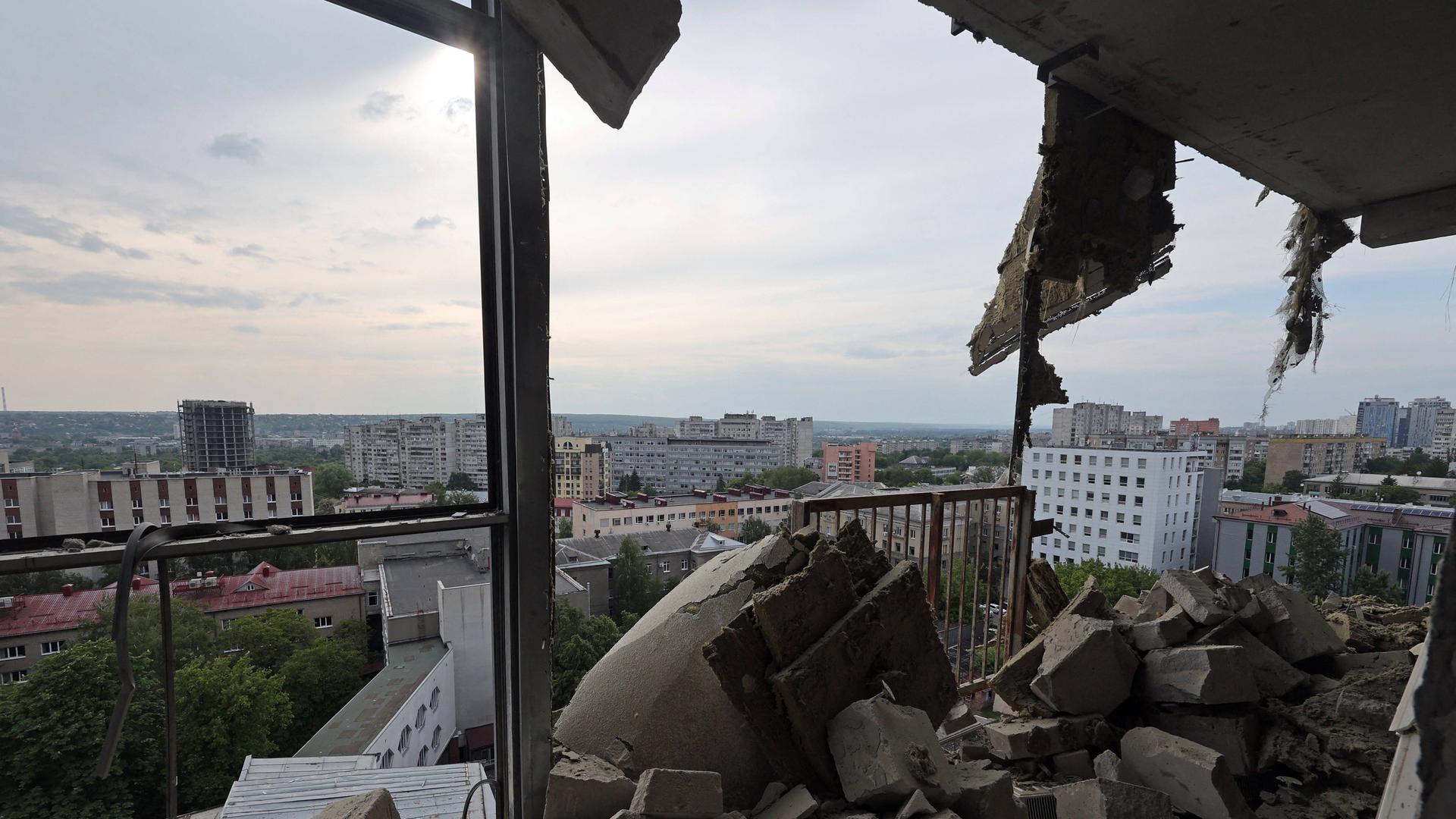 Ein zerstörtes Gebäude in der Stadt Charkiw in der Ukraine nach einem russischen Angriff. Der Blick fällt vom Gebäude hinaus über die Stadt. (14. Mai 2024)