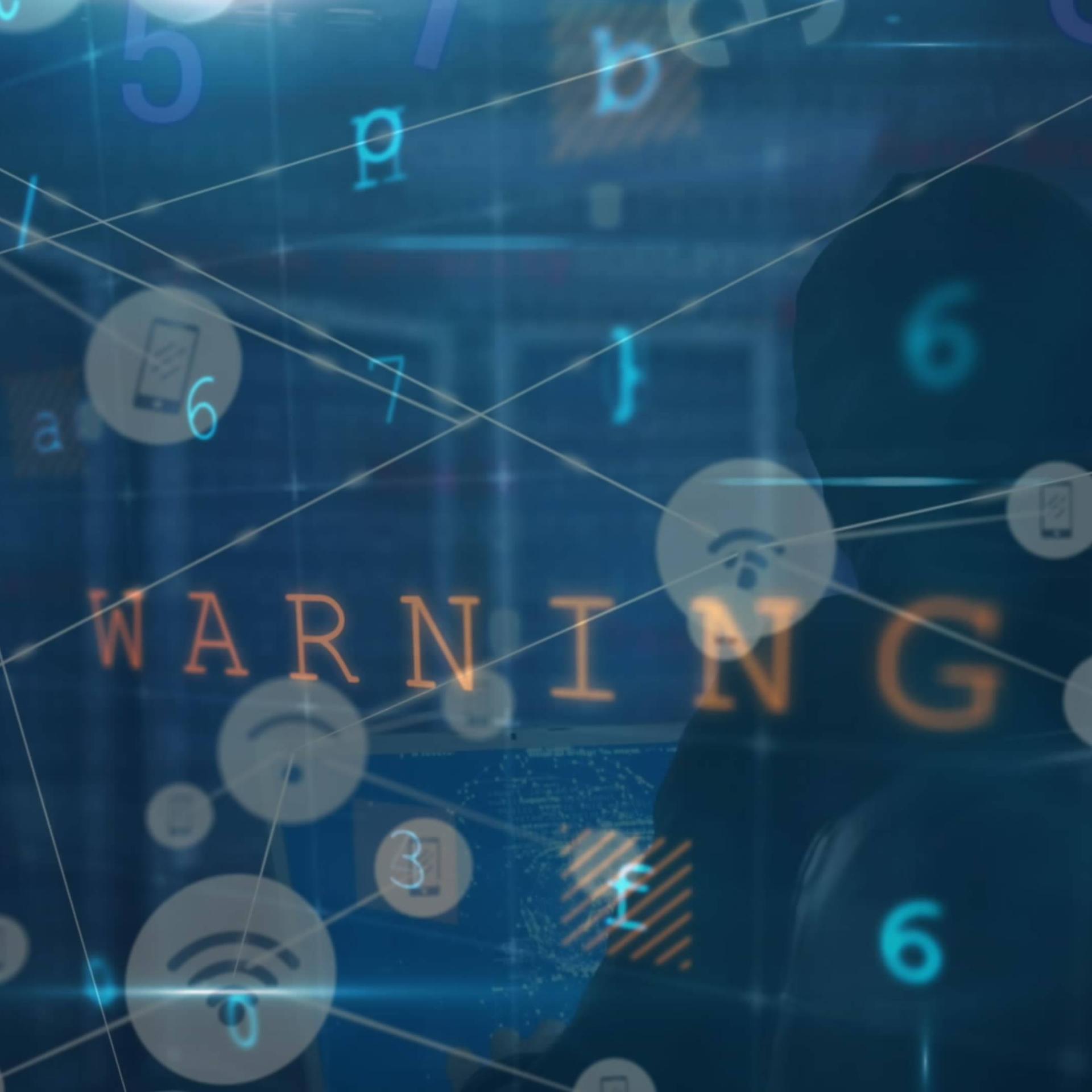 Symbolbild für Cyberangriff: Datenverarbeitung auf einem Bildschirm mit Aufschrift "Warnung" und Hacker. im Hintergrund