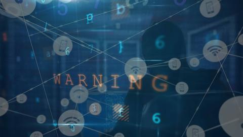 Datenverarbeitung auf einem Bildschirm mit Aufschrift "Warning" und Hacker im Hintergrund