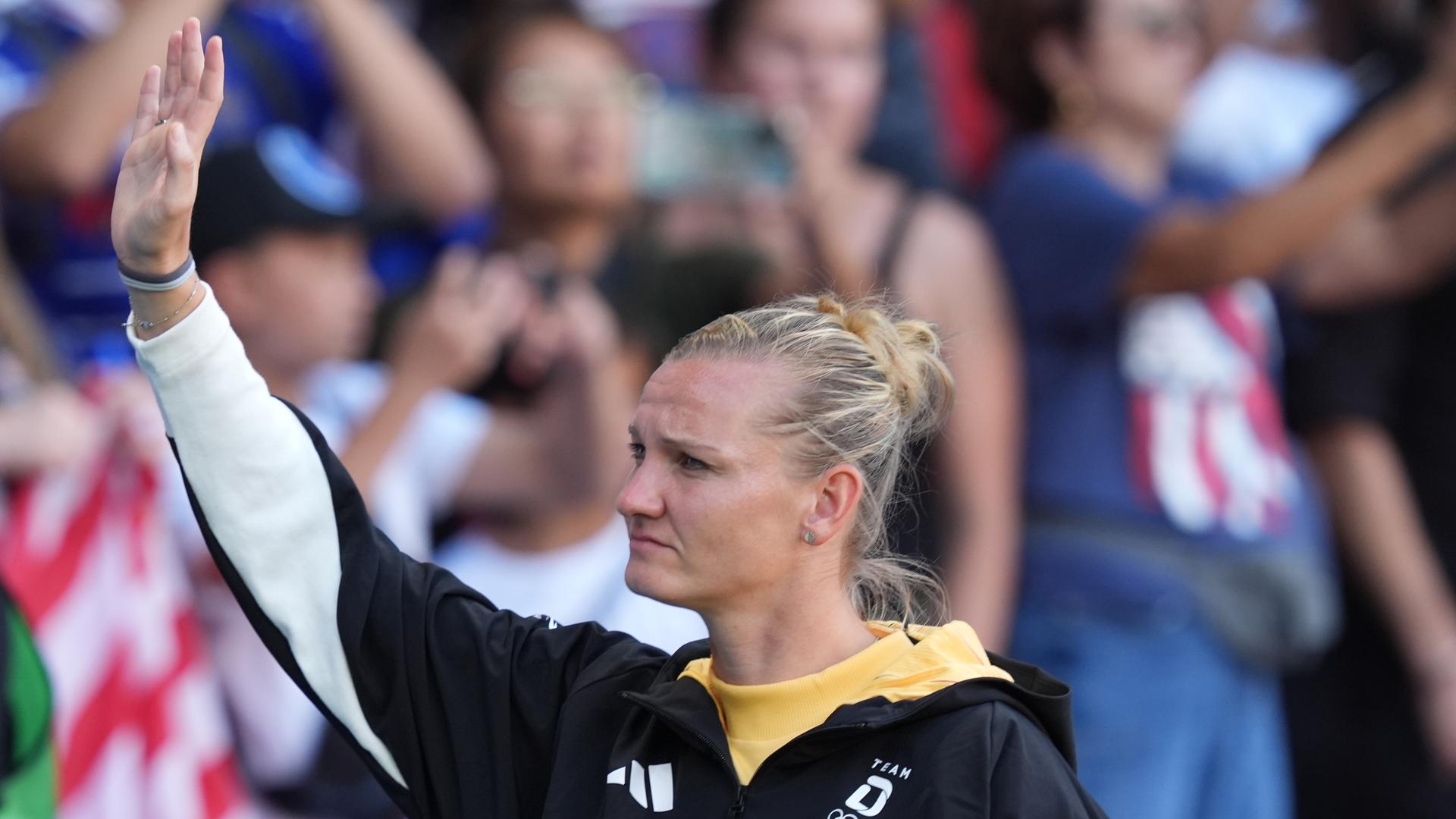 Die deutsche Fußball-Nationalspielerin Alexandra Popp winkt vor der Medaillenzeremonie bei den Olympischen Spielen in Paris ins Publikum.