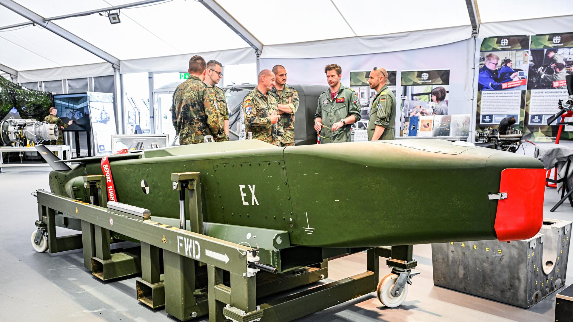 Soldaten stehen hinter einem Taurus-Marschflugkoerper einen Tag vor dem Start der Internationalen Luft- und Raumfahrtausstellung auf dem Gelaende vom Flughafen Berlin Brandenburg (BER). 