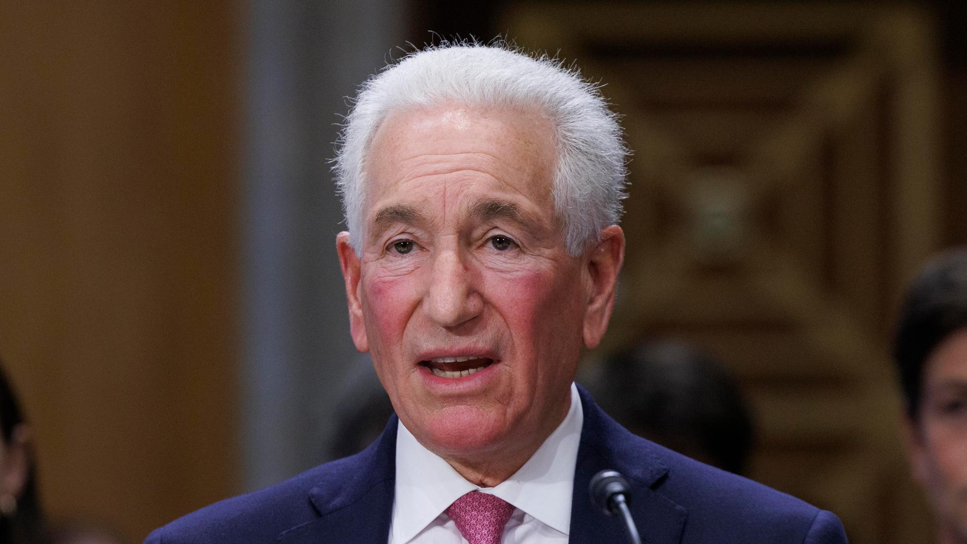 Charles Kushner spricht in ein Mikrofon. Charles Kushner spricht in ein Mikrofon.