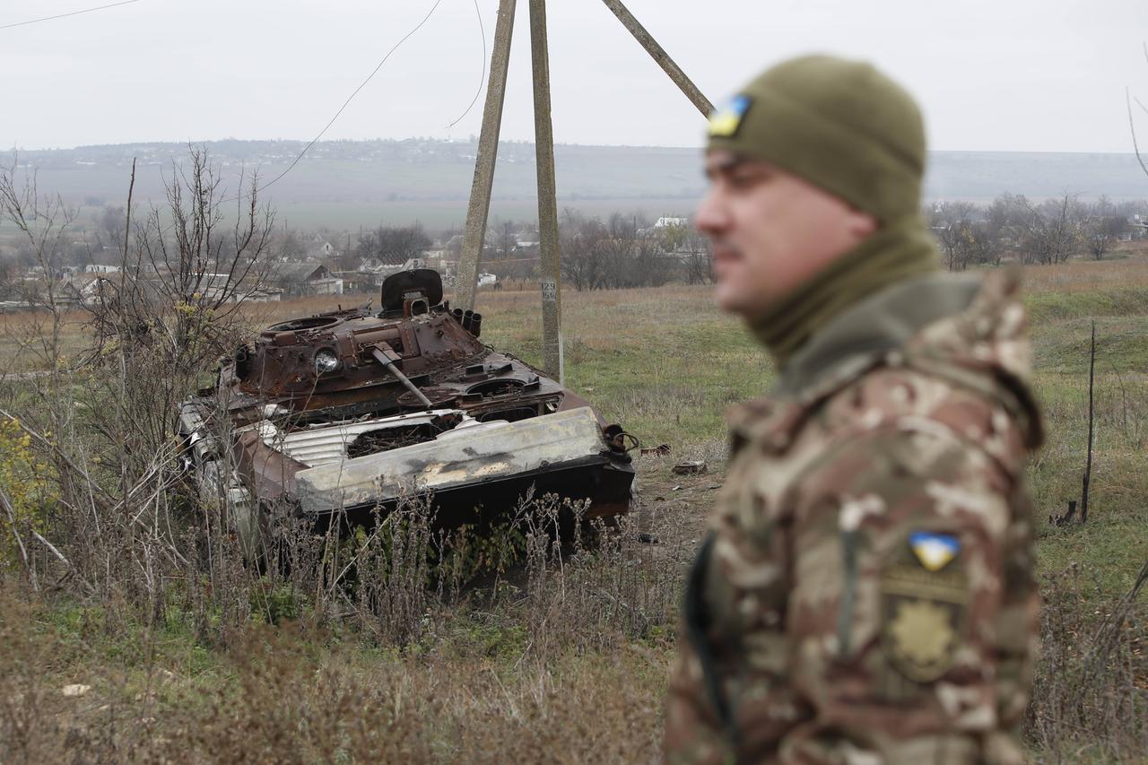 Ein ukrainischer Soldat steht vor einem zerstörten Panzer in der südukrainischen Region Cherson.