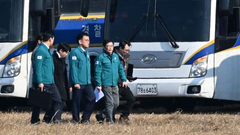 Südkoreas geschäftsführender Präsident Choi Sang Mok läuft mit mehreren Begleitern über das Flugfeld