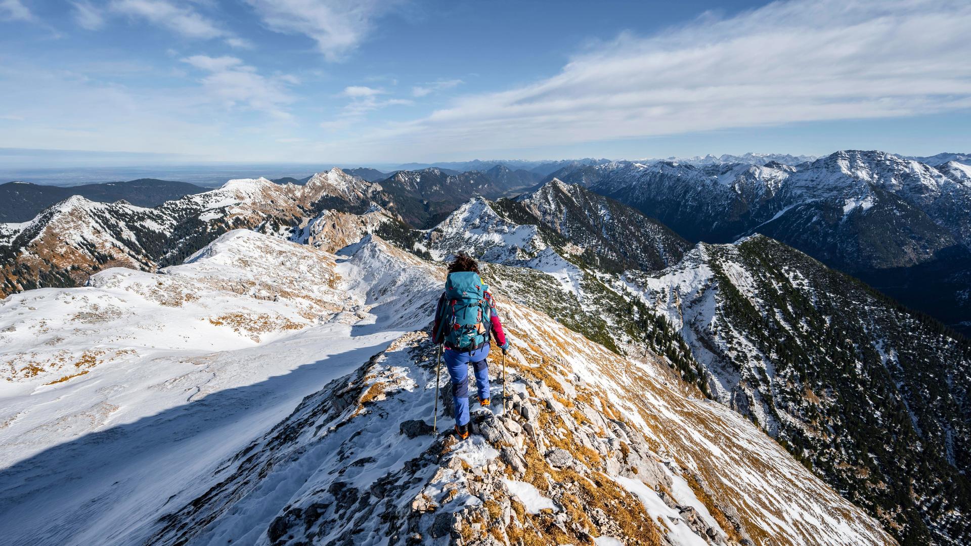 Bergsteigerin am schmalen felsigen verschneiten Grat der Ammergauer Hochplatte, Blick Richtung Lösertaljoch, Ausblick auf Bergpanorama