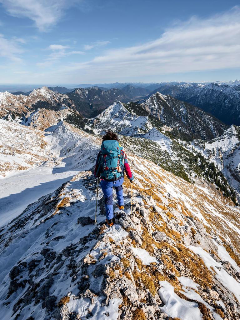 Bergsteigerin am schmalen felsigen verschneiten Grat der Ammergauer Hochplatte, Blick Richtung Lösertaljoch, Ausblick auf Bergpanorama