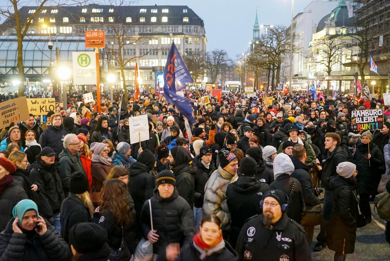 Aus einer Menschenmenge ragen Plakate mit Aufschriften wie "Hamburg bleibt bunt".