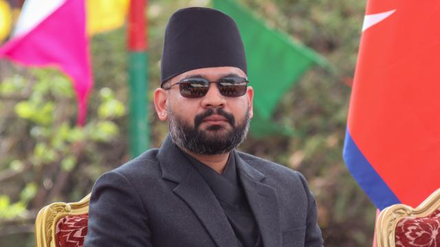 Zu sehen ist Balendra Shah, der neue Regierungs-Chef von dem Land Nepal. Er trägt eine Sonnenbrille und schaut in die Kamera.