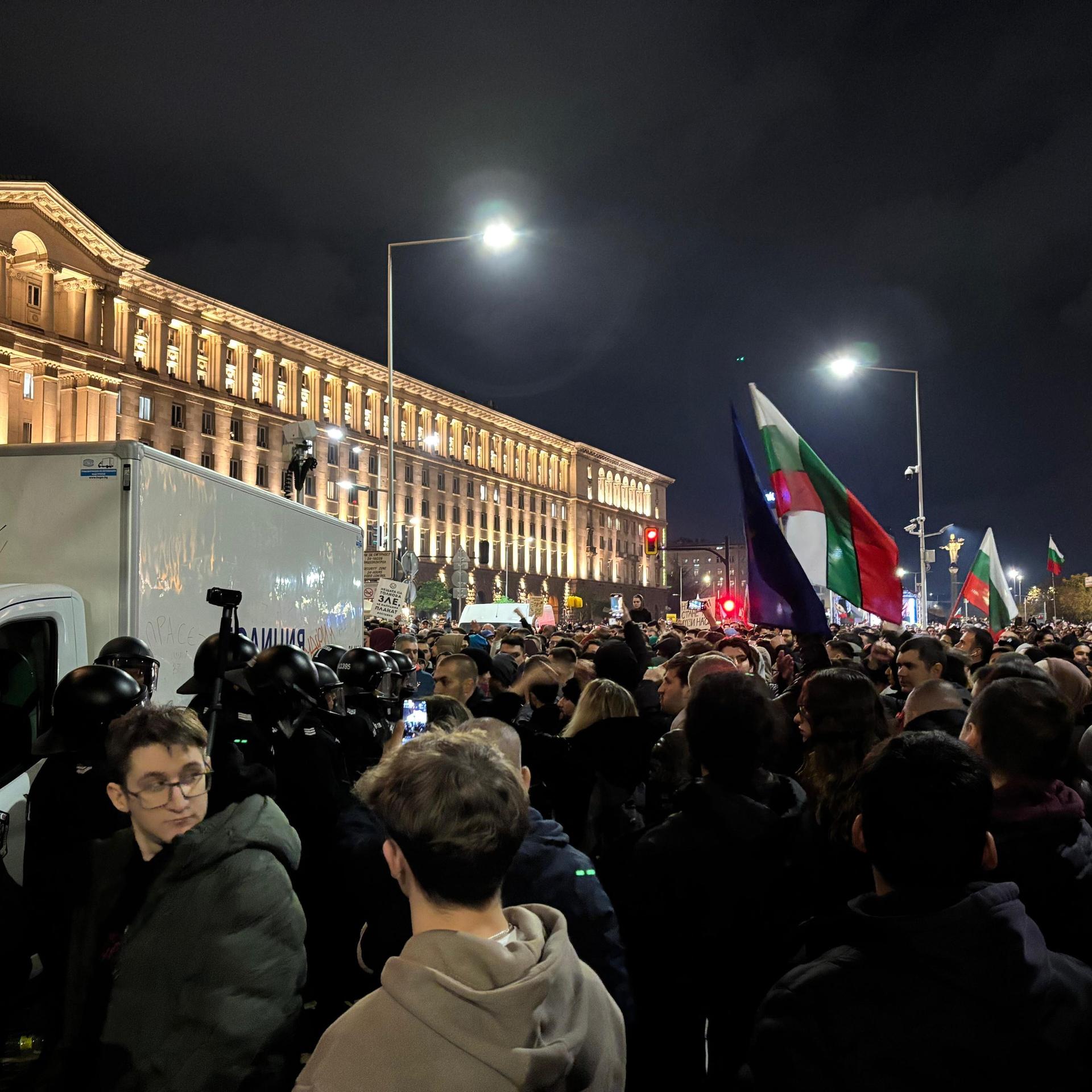 Tausende Menschen stehen am Independence Platz in Sofia, einige halten Fahnen hoch.