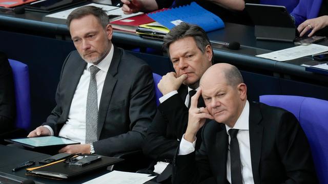 Bundeskanzler Olaf Scholz (SPD), Wirtschaftsminister Robert Habeck (Gruene) und Frinanzminister Christian Lindner gemeinsam nachdenklich und mit fragendem Blick auf der Regierungsbank bei der 150. Sitzung des Deutschen Bundestag in Berlin, 31.01.2024