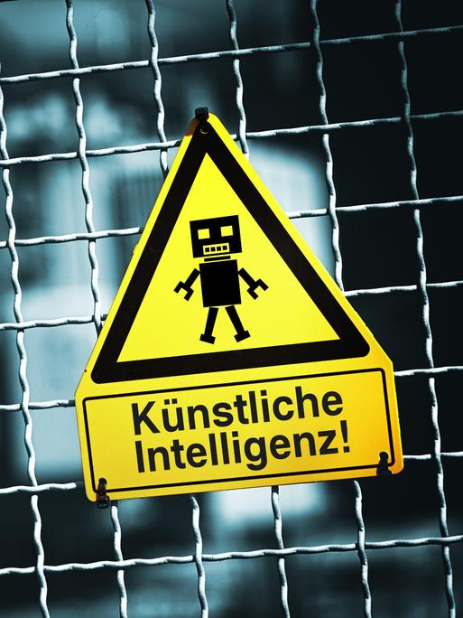 Roboterfigur auf einem Warnschild mit Aufschrift Künstliche Intelligenz (Symbolbild) Roboterfigur auf einem Warnschild mit Aufschrift Künstliche Intelligenz (Symbolbild)