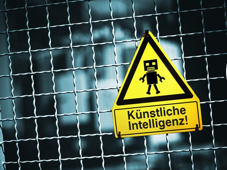 Roboterfigur auf einem Warnschild mit Aufschrift Künstliche Intelligenz (Symbolbild) Roboterfigur auf einem Warnschild mit Aufschrift Künstliche Intelligenz (Symbolbild)