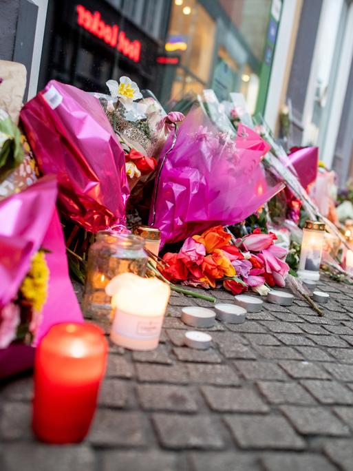 Zahlreiche Blumen und Kerzen stehen in der Oldenburger Innenstadt an einer Hauswand.