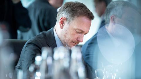 Christian Lindner sitzt in nachdenklicher Pose an einem Tisch
