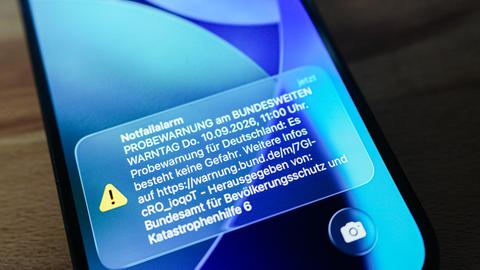 Das Display eines Smartphones zeigt die Meldung zum Probealarm an. 