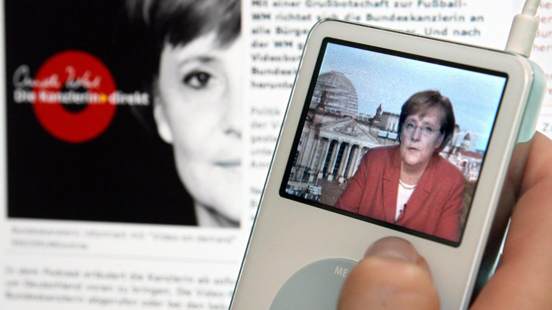 Eine junge Frau schaut sich auf ihrem Apple iPod den ersten Video-Podcast "Angela Merkel - die Kanzlerin direkt" von Bundeskanzlerin Angela Merkel an Eine junge Frau schaut sich auf ihrem Apple iPod den ersten Video-Podcast "Angela Merkel - die Kanzlerin direkt" von Bundeskanzlerin Angela Merkel an