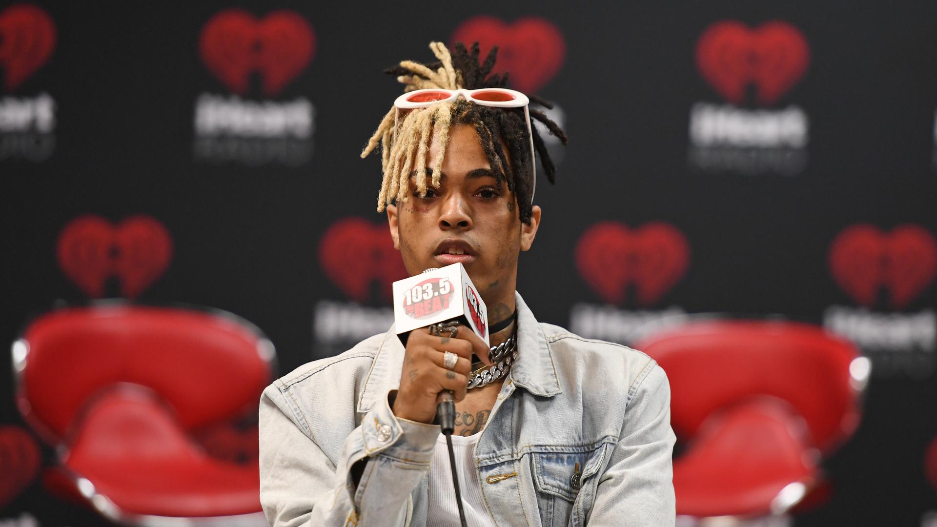 XXXTentacion hält während eines Interviews ein Mikro in der Hand und blickt in die Kamera. XXXTentacion hält während eines Interviews ein Mikro in der Hand und blickt in die Kamera.