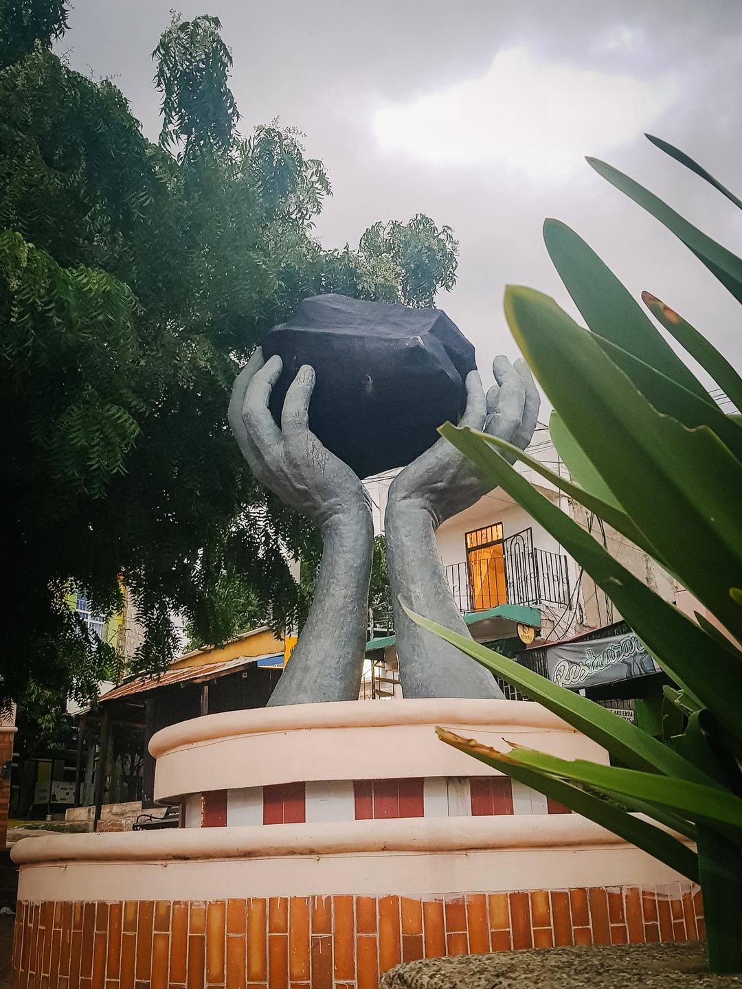 Monument für die Kohleförderung in Albania: Zwei überdimensionale Hände halten einen als schwarzen Kohlebrocken angemalten Klotz in die Höhe. 