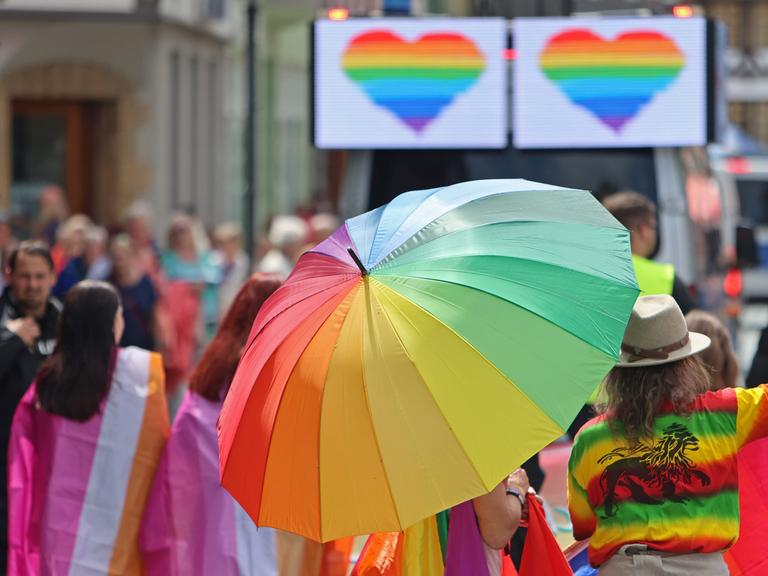 Teilnehmer des Christopher Street Day (CSD) ziehen mit bunten Regenschirmen durch die Stadt Werningerode. 