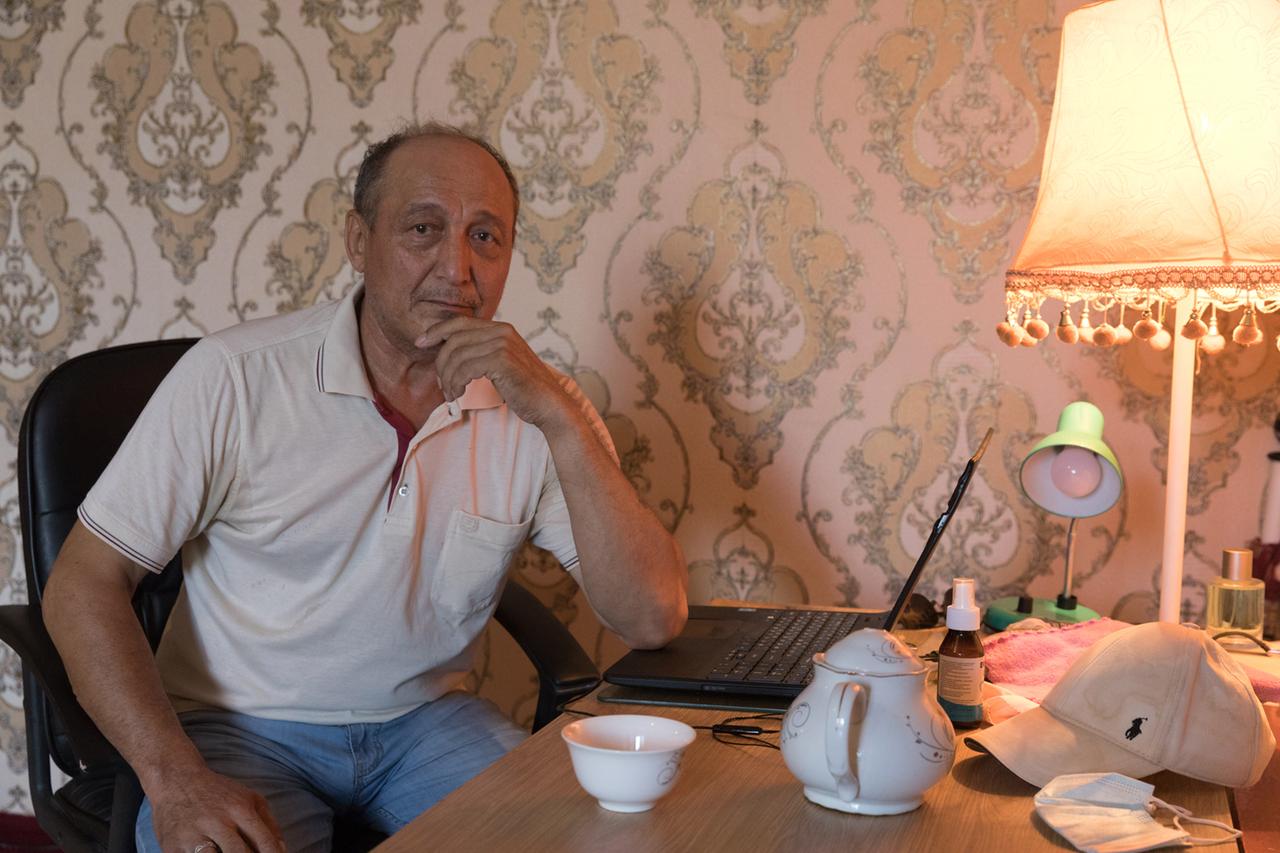 Azimbay Ataniyazov sitzt an einem Tisch