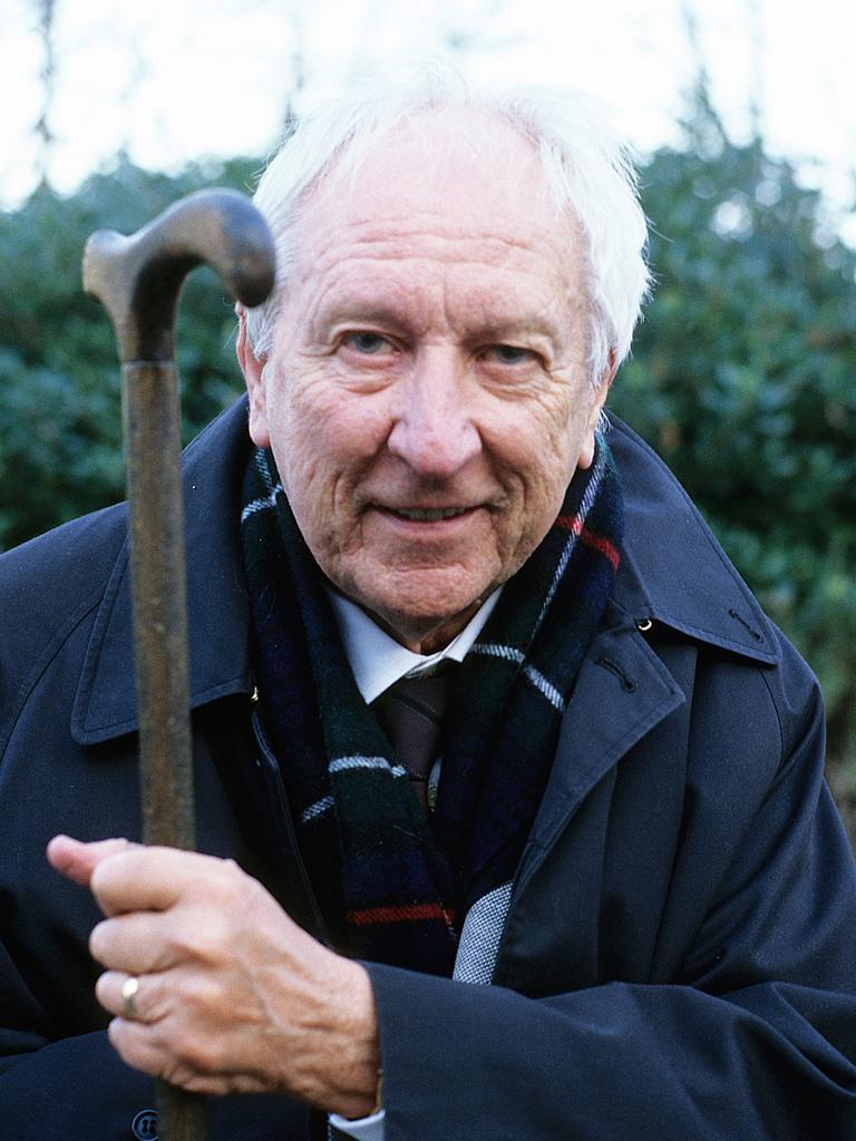 Porträt des schwedischen Autors und Poeten Tomas Tranströmer. Er trägt einen blauen Mantel, ein weisses Hemd, einen karierten Schaal und hält mit der linken Hand seinen Gehstock hoch.