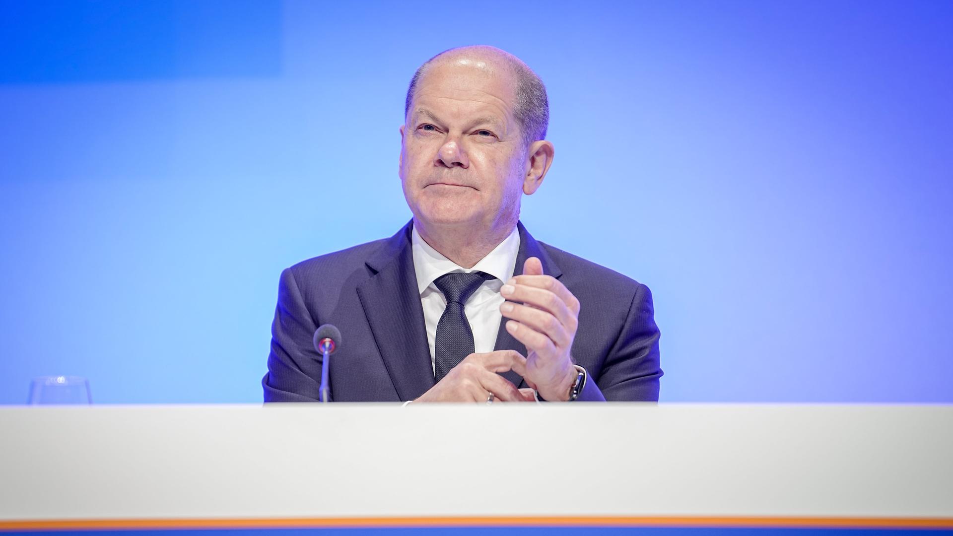 Bundeskanzler Olaf Scholz (SPD) sitzt auf dem Podium des CDU-Wirtschaftstages 2023.