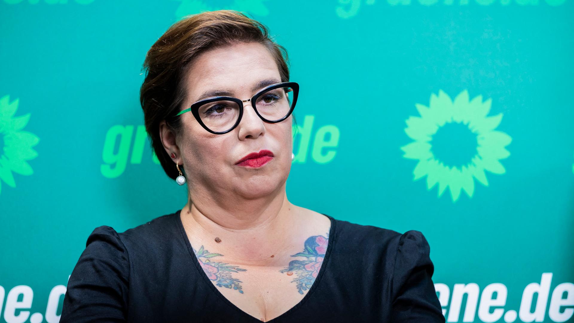 Susan Sziborra-Seidlitz steht bei einer Pressekonferenz vor einem Banner der Grünen. 