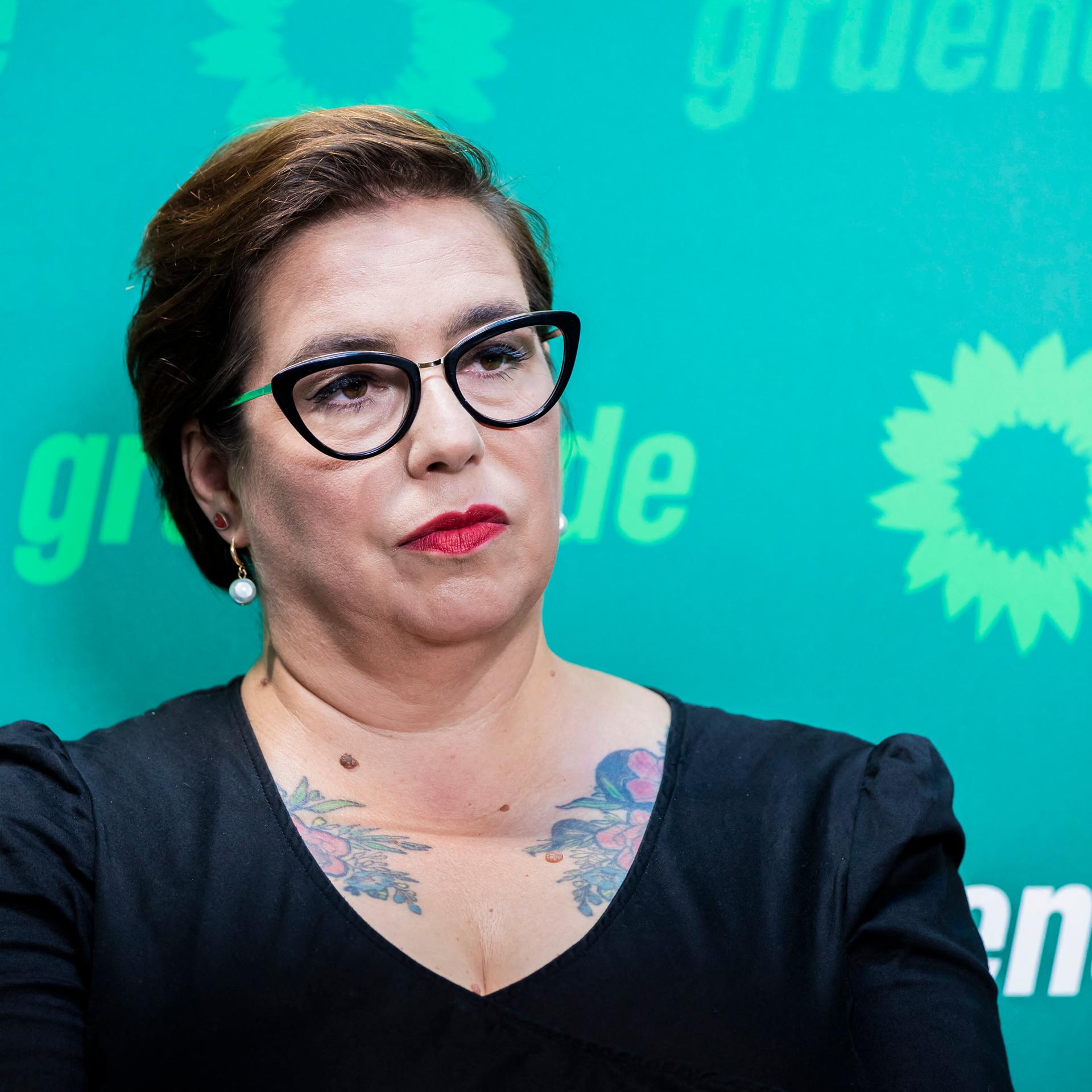 Susan Sziborra-Seidlitz steht bei einer Pressekonferenz vor einem Banner der Grünen. 