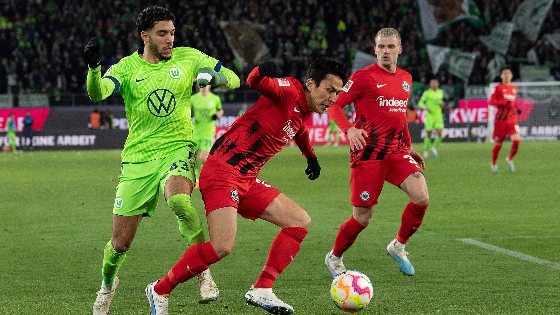 Hasebe im roten Trikot deckt den Ball ab, hinter ihm im grünen Trikot Marmoush. Der Leverkusener Mitchell Bakker beobachtet die Szene. Hasebe im roten Trikot deckt den Ball ab, hinter ihm im grünen Trikot Marmoush. Der Leverkusener Mitchell Bakker beobachtet die Szene.