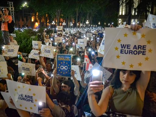 June 20, 2022, Tbilisi, Georgia: Pro EU protesters hold their smartphone with the flashlight on and placards written on