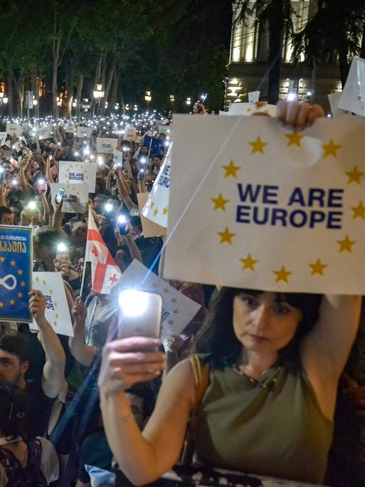 June 20, 2022, Tbilisi, Georgia: Pro EU protesters hold their smartphone with the flashlight on and placards written on