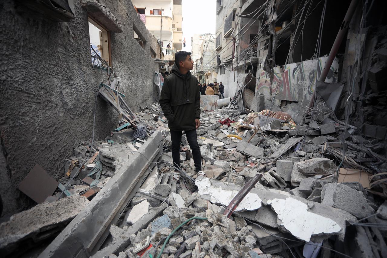 Ein junger Palästinenser steht zwischen kaputten Häusern (16.01.2024) 
