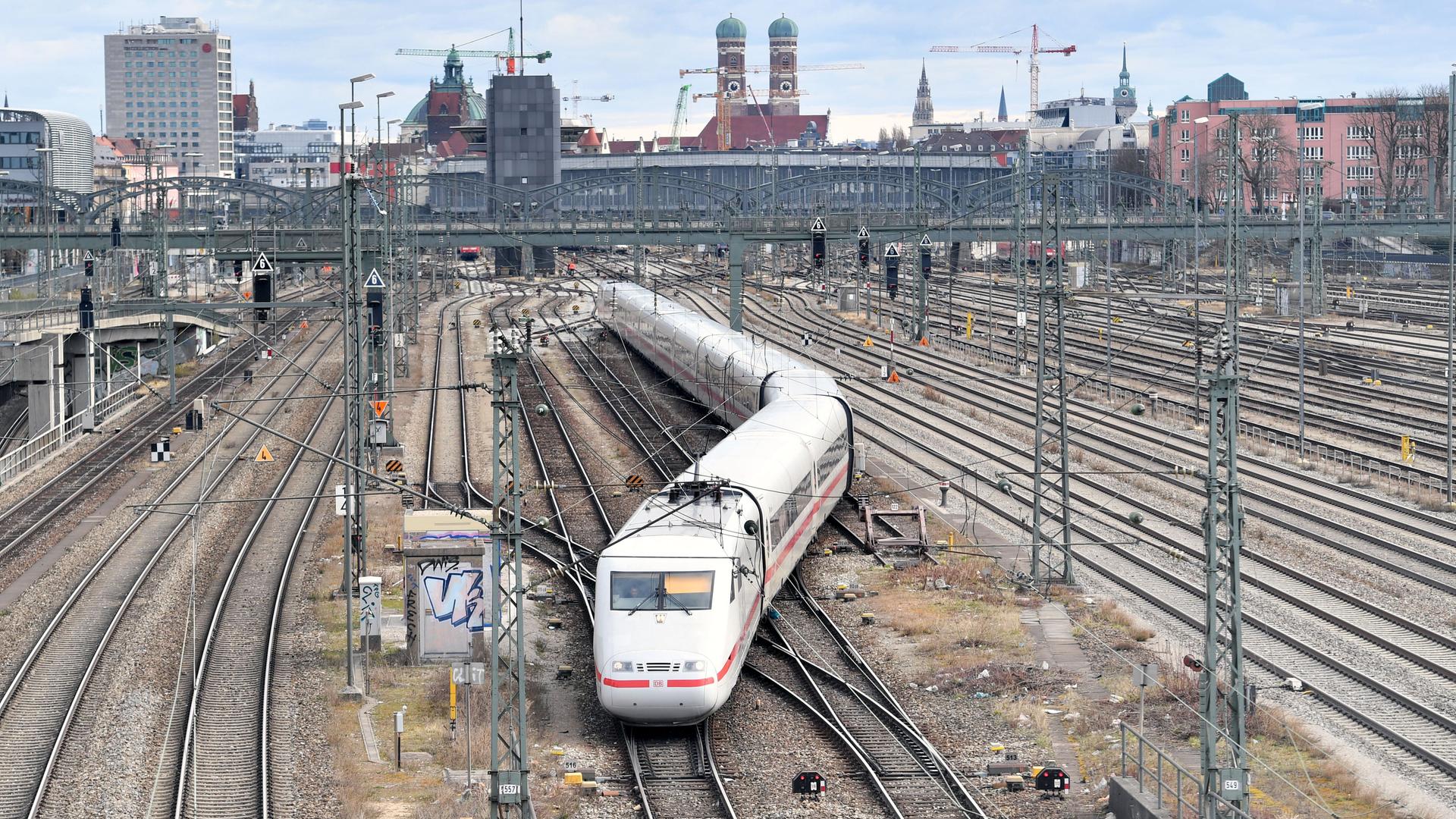 Blick von oben auf den Hauptbahnhof Hauptbahnhof in München, wo auf einem Gleis gerade ein Intercity Express abfährt. 