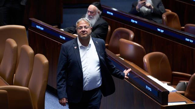 Ben-Gvir steht zwischen den Sitzreihen im israelischen Parlament und schaut in die Kamera.