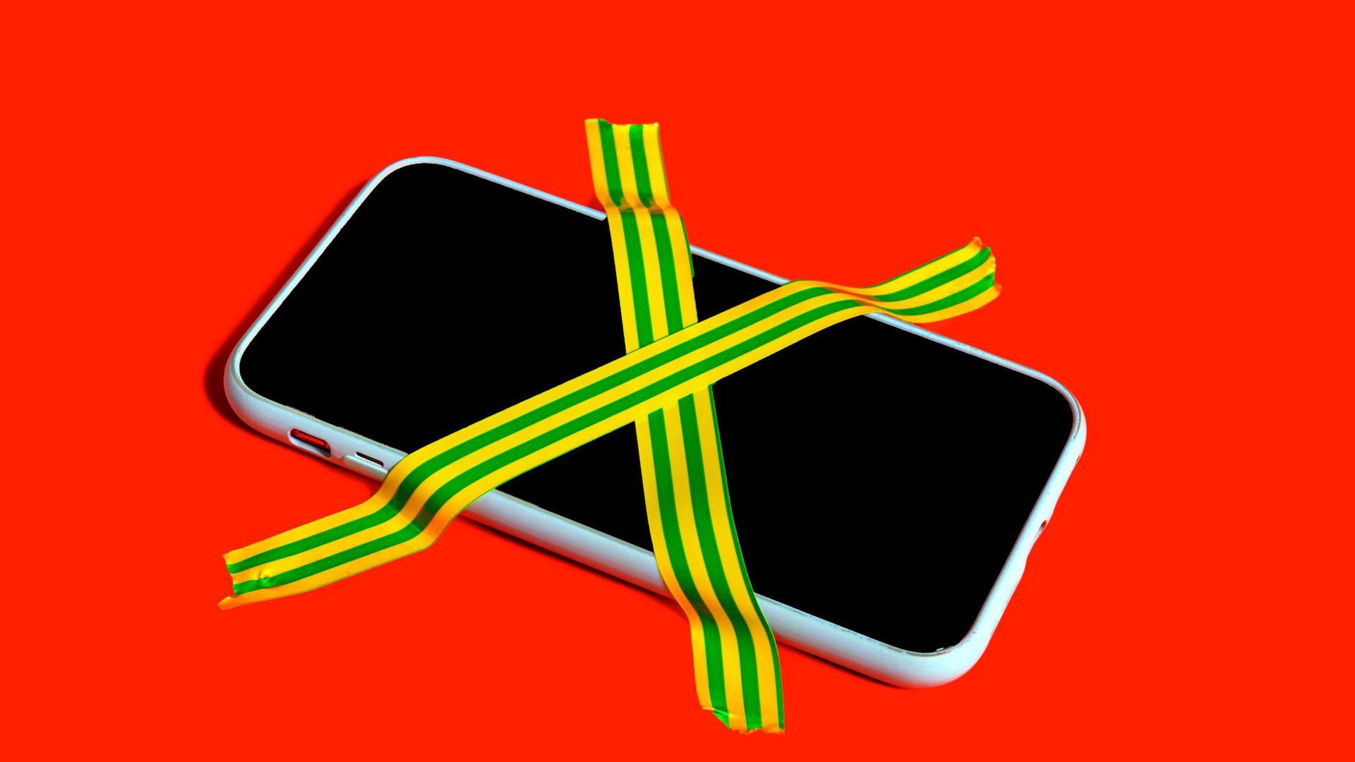 Farbenfrohes Stillleben eines Smartphones mit kreuzweise geklebten Klebebändern als Symbol für digitale Entgiftung und Handyverzicht