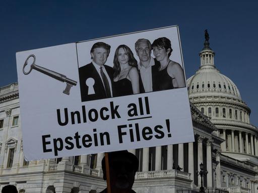 Vor dem US-Kapiton in Washington hält ein Demonstrant ein Schild mit der Aufschrift "Unlock all Epstein Files" in die Höhe.