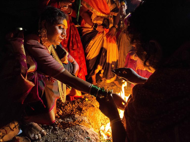 Eine Hijra in Indien bei einem religiösen Ritual an einem Feuer.
