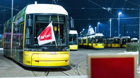 Berlin: Eine Fahne der Gewerkschaft Verdi weht an einer Straßenbahn der Berliner Verkehrsbetriebe BVG hinter der geschlossenen Ausfahrt im Betriebshof Lichtenberg.