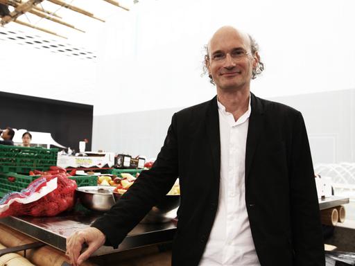 Der Architekt Nikolaus Hirsch steht auf der Art Basel und guckt in die Kamera. Er trägt ein weißes Hemd und eine schwarze Jacke. Der Architekt Nikolaus Hirsch steht auf der Art Basel und guckt in die Kamera. Er trägt ein weißes Hemd und eine schwarze Jacke.