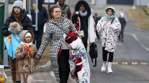 Geflüchtete ukrainische Frauen und ihre Kinder, die gerade über die Grenze nach Polen kommen.  