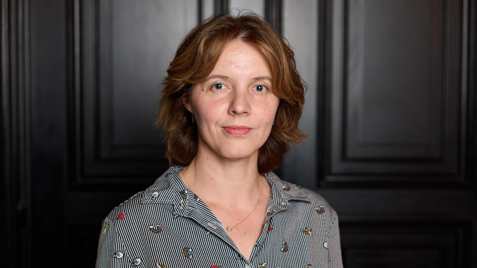 Portraitfoto von Peggy Mädler vor einer dunklen Tür