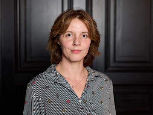 Portraitfoto von Peggy Mädler vor einer dunklen Tür