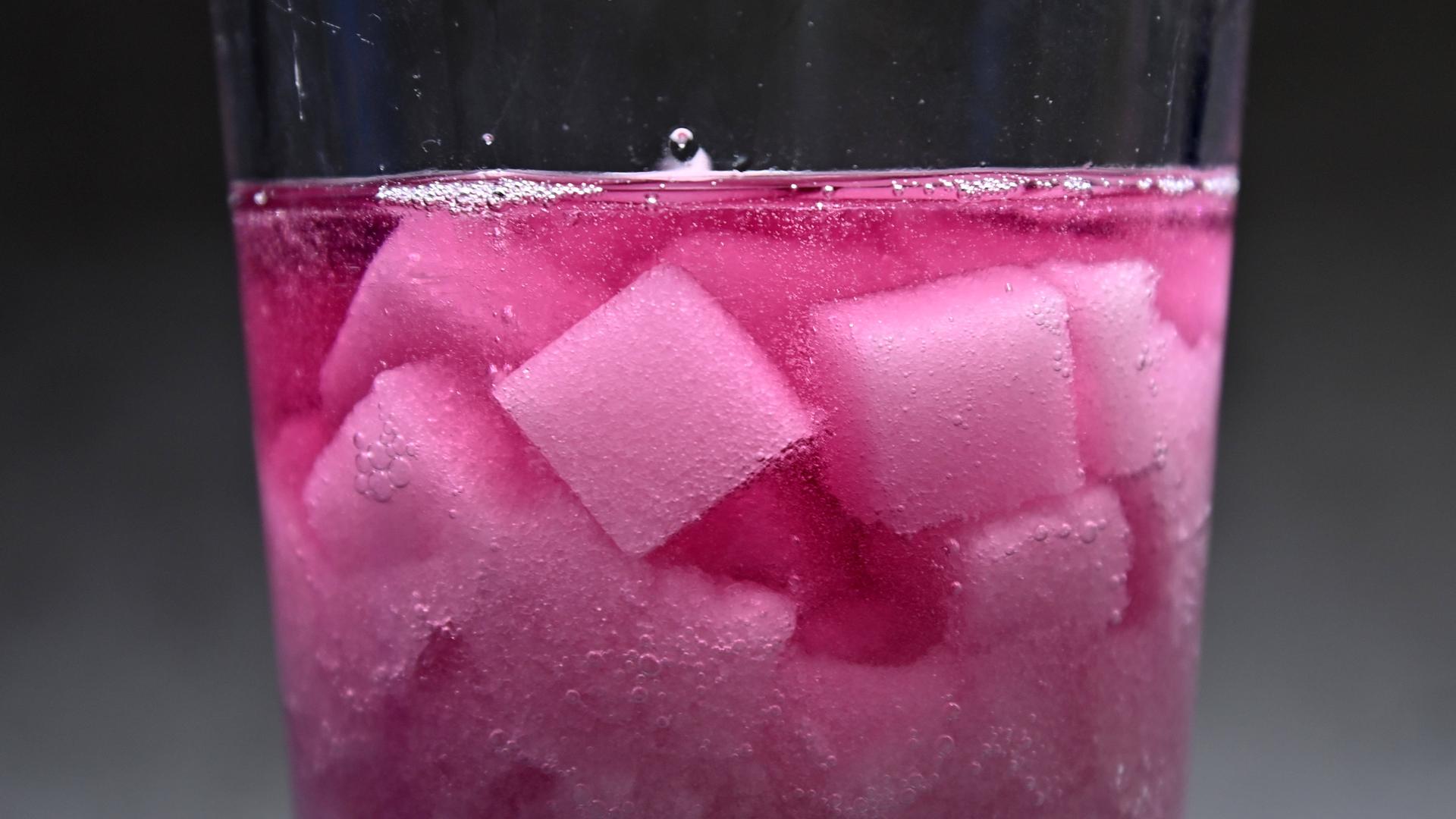 Zuckerwürfel lösen sich in einem Glas zuckerhaltiger Brauselimonade auf als Symbol fuer die Diskussion um eine Zuckersteuer 
