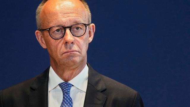 Bundeskanzler Friedrich Merz schaut ernst. Er trägt ein schwarzes Jackett, weißes Hemd und blaue Krawatte. 