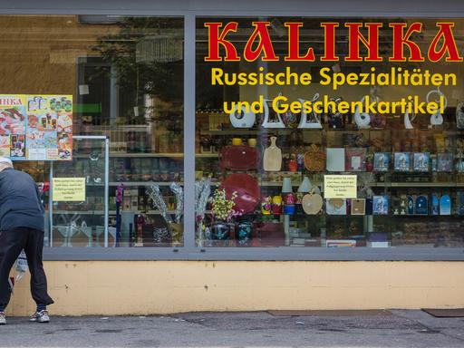 Ein älterer Mann steht mit seinem Fahrrad vor einem russischen Spezialitätengeschäft in Ludwigsburg Ein älterer Mann steht mit seinem Fahrrad vor einem russischen Spezialitätengeschäft in Ludwigsburg